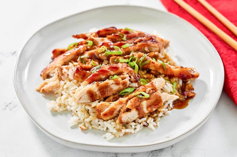 Copycat Panda Express grilled teriyaki chicken over rice on a plate.