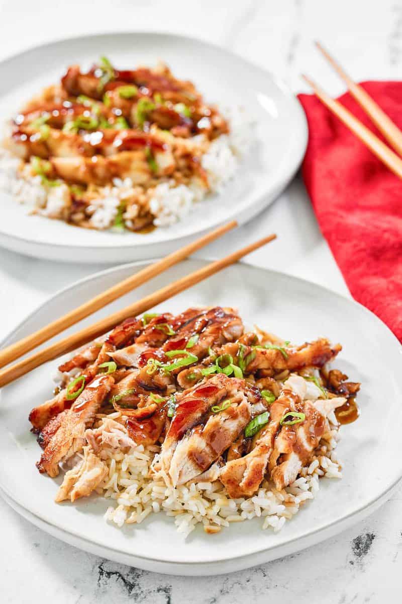 Copycat Panda Express grilled teriyaki chicken over rice on two plates.