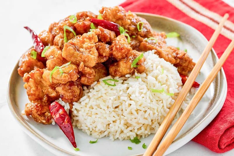 Copycat Panda Express hot orange chicken served with rice on a plate.