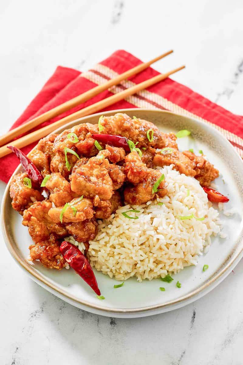 Copycat Panda Express hot orange chicken and rice on a plate.