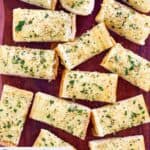 Homemade Brennan's garlic bread slices on a wood cutting board.