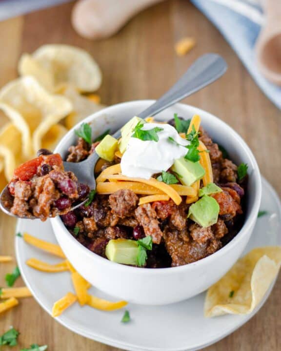 Chili on a spoon on top of a bowl of chili.