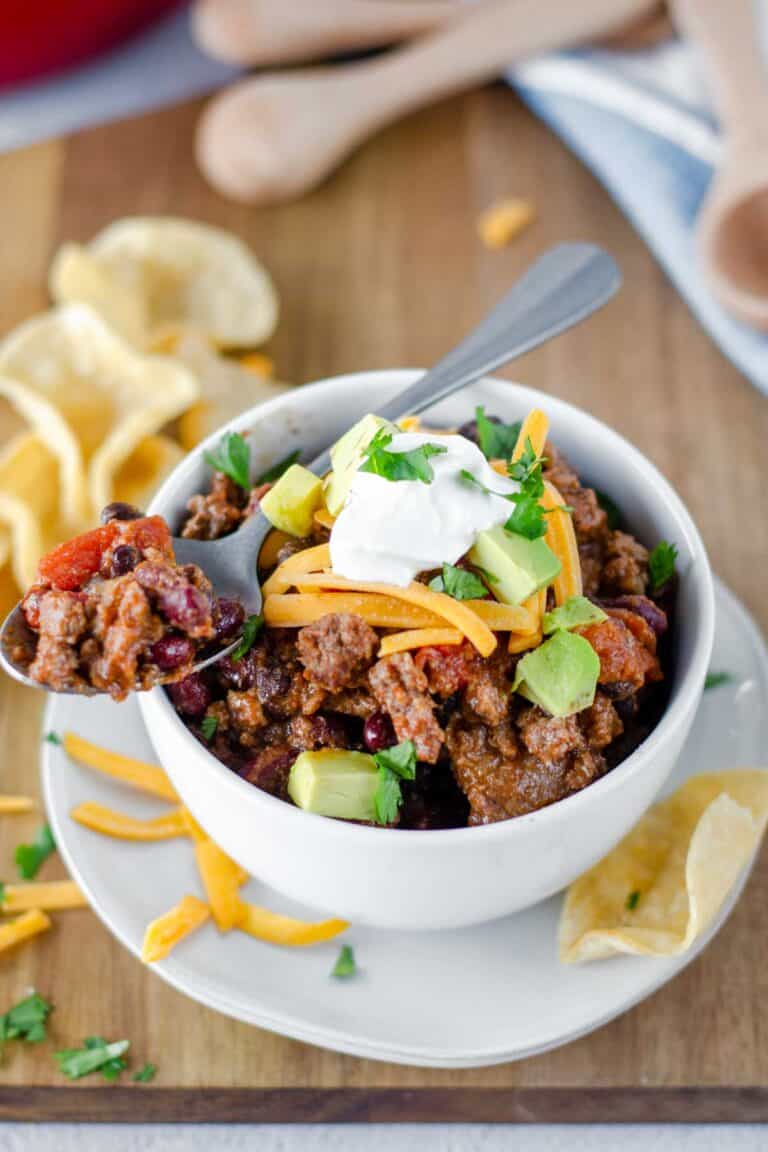 Chili on a spoon on top of a bowl of chili.