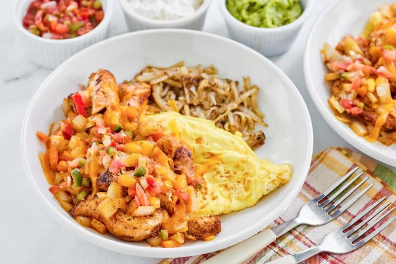 Copycat Denny's chicken fajita breakfast skillet, salsa, sour cream, and guacamole.