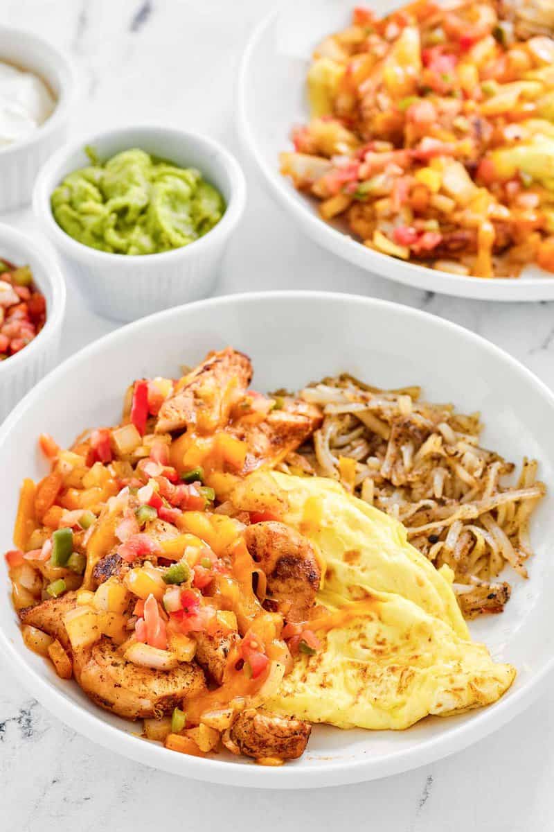 Copycat Denny's chicken fajita breakfast skillet, guacamole, salsa, and sour cream.