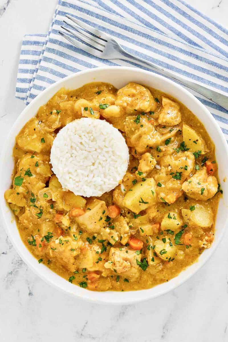 Instant Pot Thai yellow chicken curry in a bowl and a fork next to it.