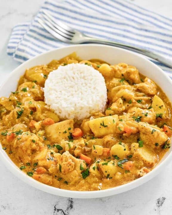 Instant Pot Thai yellow chicken curry in a bowl and a fork on a napkin.