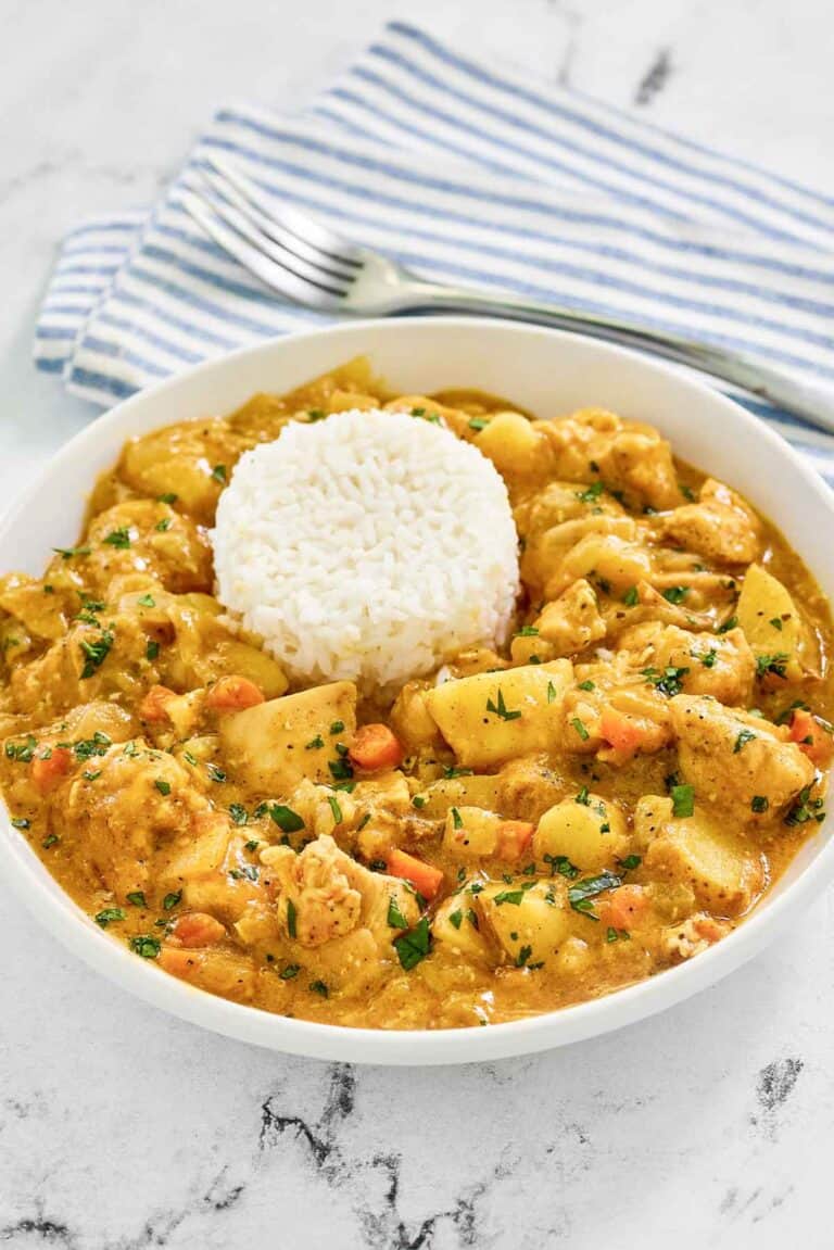 Instant Pot Thai yellow chicken curry in a bowl and a fork on a napkin.