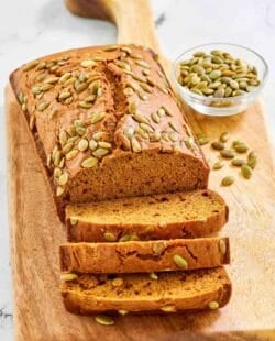 Copycat starbucks pumpkin bread and a small bowl of pumpkin seeds.