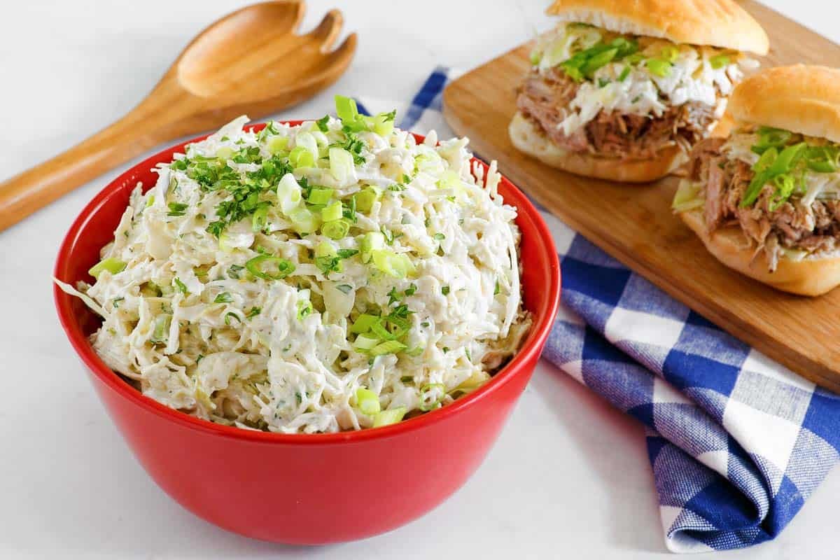 Creamy, sweet, and tangy cabbage slaw in a bowl and on sandwiches.