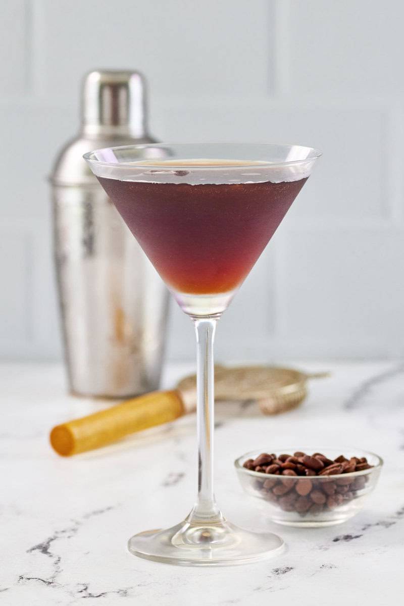 Copycat chili's espresso martini, cocktail shaker, and espresso coffee beans.