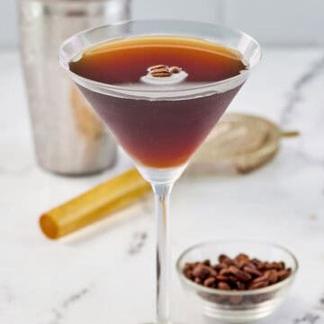 Copycat chili's espresso martini and a small bowl of espresso coffee beans.