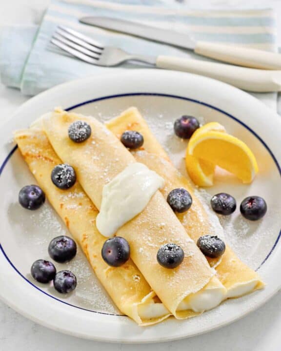 Copycat ihop lemon ricotta crepes on a plate.