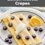 Homemade ihop lemon ricotta crepes, lemon wedges, and fresh blueberries.