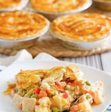 Copycat KFC chicken pot pie on a plate and more pies behind it.