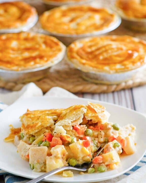 Copycat KFC chicken pot pie on a plate and more pies behind it.