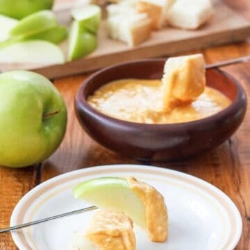 Copycat Melting Pot cheddar cheese fondue with sliced apples and bread cubes.