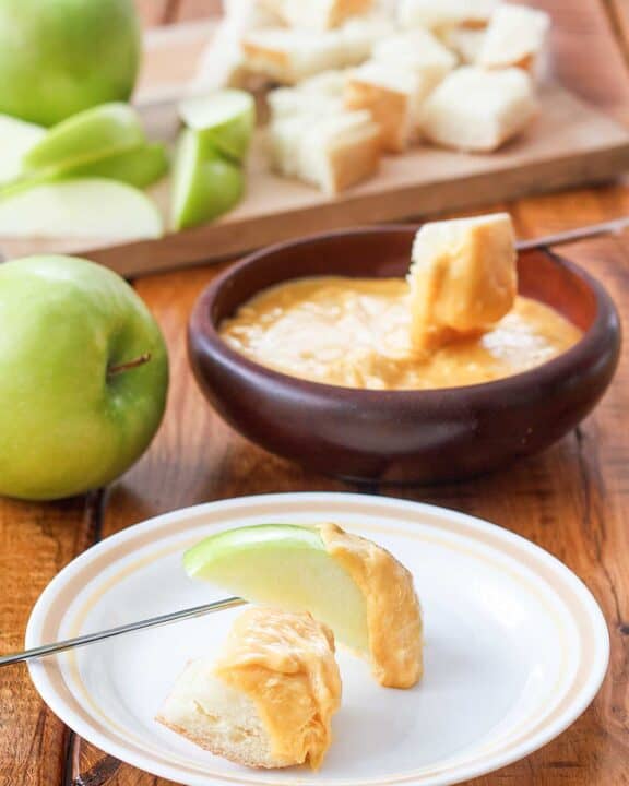 Copycat Melting Pot cheddar cheese fondue with sliced apples and bread cubes.