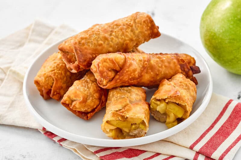 Copycat panda express apple pie egg rolls piled on a plate.