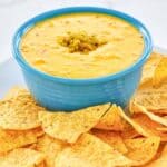 Homemade pappasito's queso dip and corn tortilla chips on a platter.