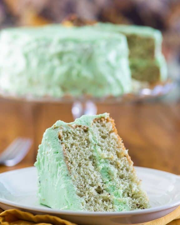 Homemade pistachio cake and a slice on a plate.