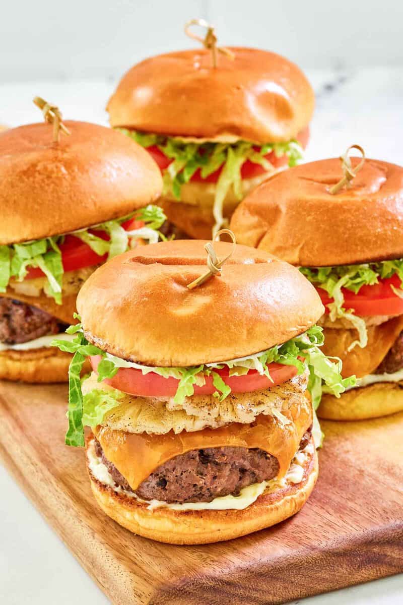 Four copycat red robin banzai burgers on a board.