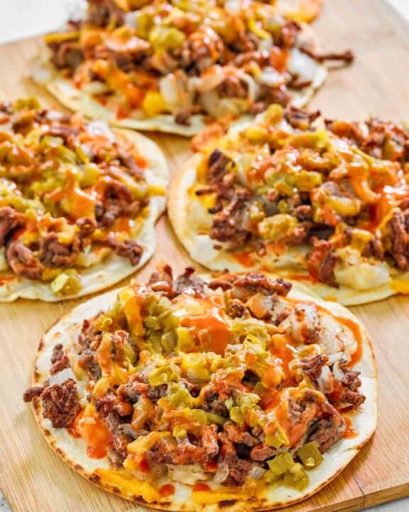 Copycat taco villa mexican pizza things on a wood serving board.