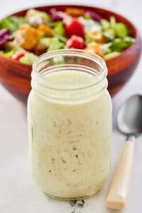 Homemade buttermilk ranch dressing, a salad, and a spoon.