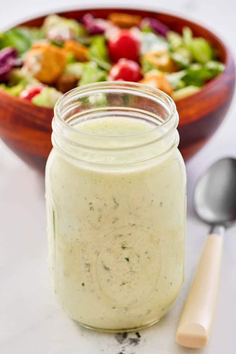 Homemade buttermilk ranch dressing, a salad, and a spoon.