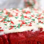 Red velvet brownies with cream cheese brownies on a wood cutting board.