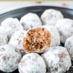 Homemade rum balls on a plate and one cut in half.