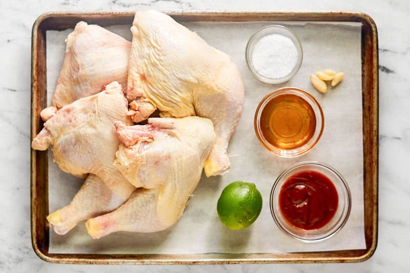 Sriracha honey glazed chicken leg quarters ingredients on a tray.