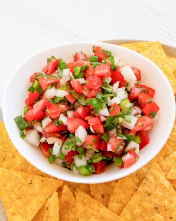 Copycat TGI Friday's pico de gallo with tortilla chips on a plate.