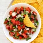 Homemade TGI Friday's pico de gallo and a tortilla chip in a bowl.