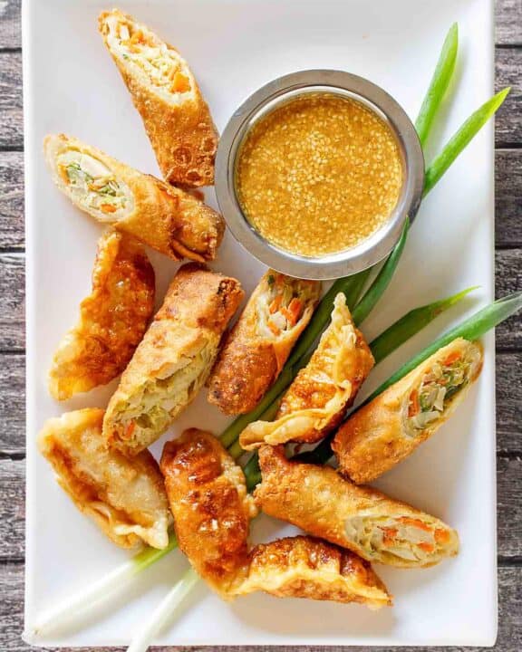 Copycat Benihana magic mustard sauce and egg rolls on a platter.