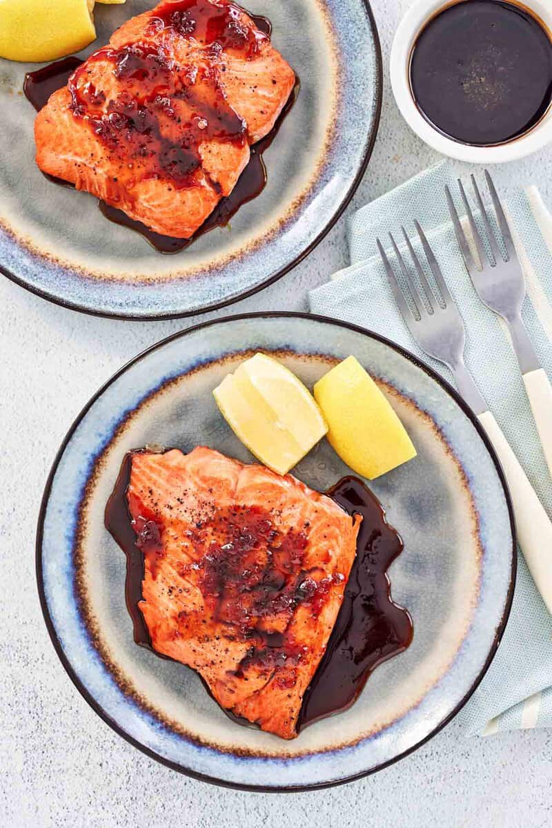 Copycat Cheddar's grilled salmon with bourbon glaze on two plates.