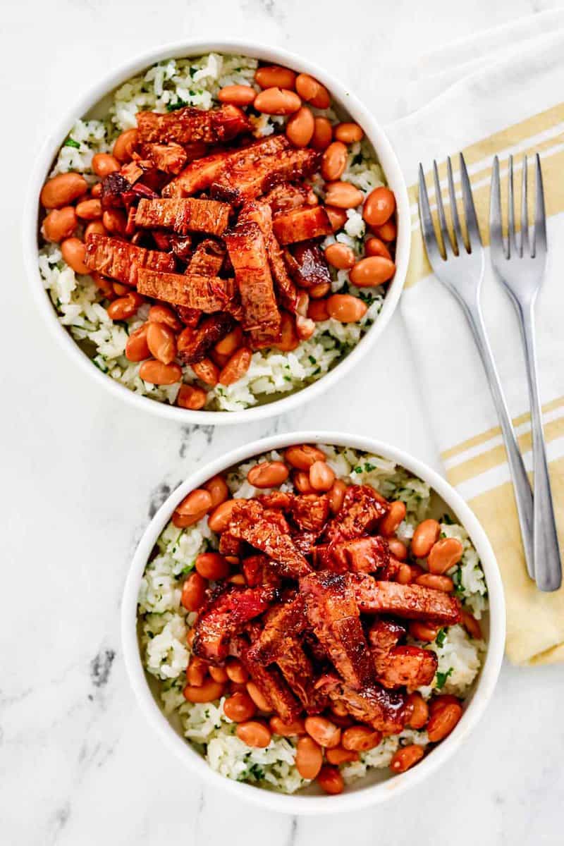 Copycat Chipotle smoked brisket over cilantro lime rice in two bowls.