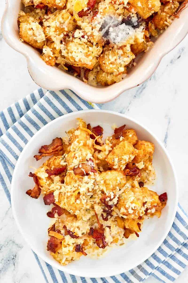 Copycat Domino's cheddar bacon loaded tots in a serving dish and on a plate.