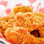 Homemade KFC fried chicken pieces in a basket lined with parchment paper.