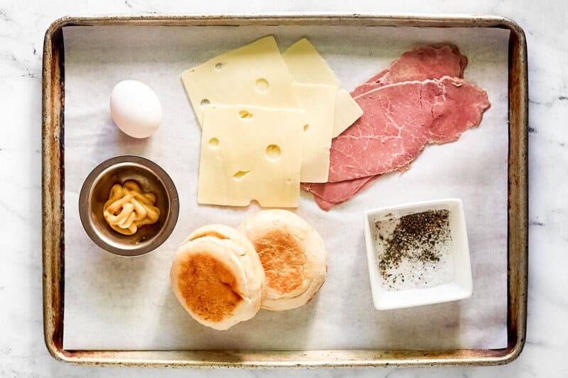 Corned beef breakfast sandwich ingredients on a tray.