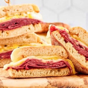 Homemade corned beef breakfast sandwiches cut in half and on a wood board.