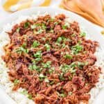 Instant pot pulled pork over rice on a platter.