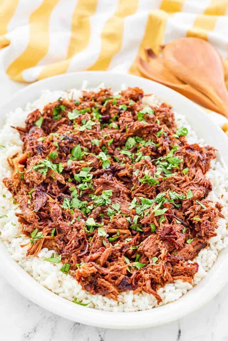 Instant pot pulled pork over rice on a platter.