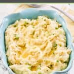 Irish champ mashed potatoes in a serving dish on a marble surface.