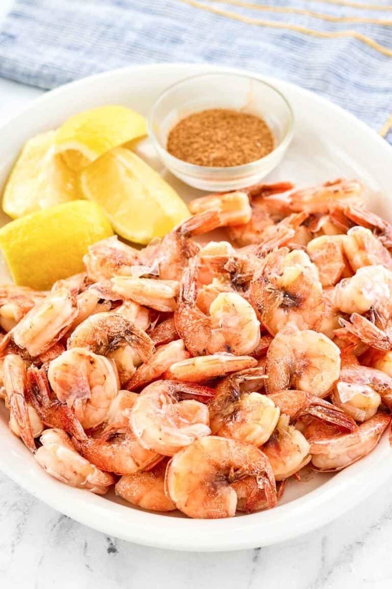 Boiled shrimp served with lemon wedges on a platter.