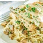 Homemade Cheesecake Factory chicken piccata over pasta on a plate.