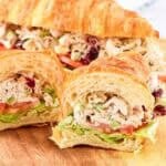 Chicken salad with cranberries and walnuts served in a croissant sandwich.