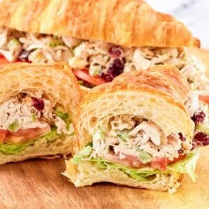 Chicken salad with cranberries and walnuts served in a croissant sandwich.