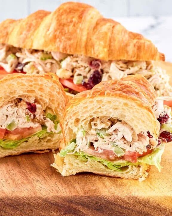 Chicken salad with cranberries and walnuts served in a croissant sandwich.