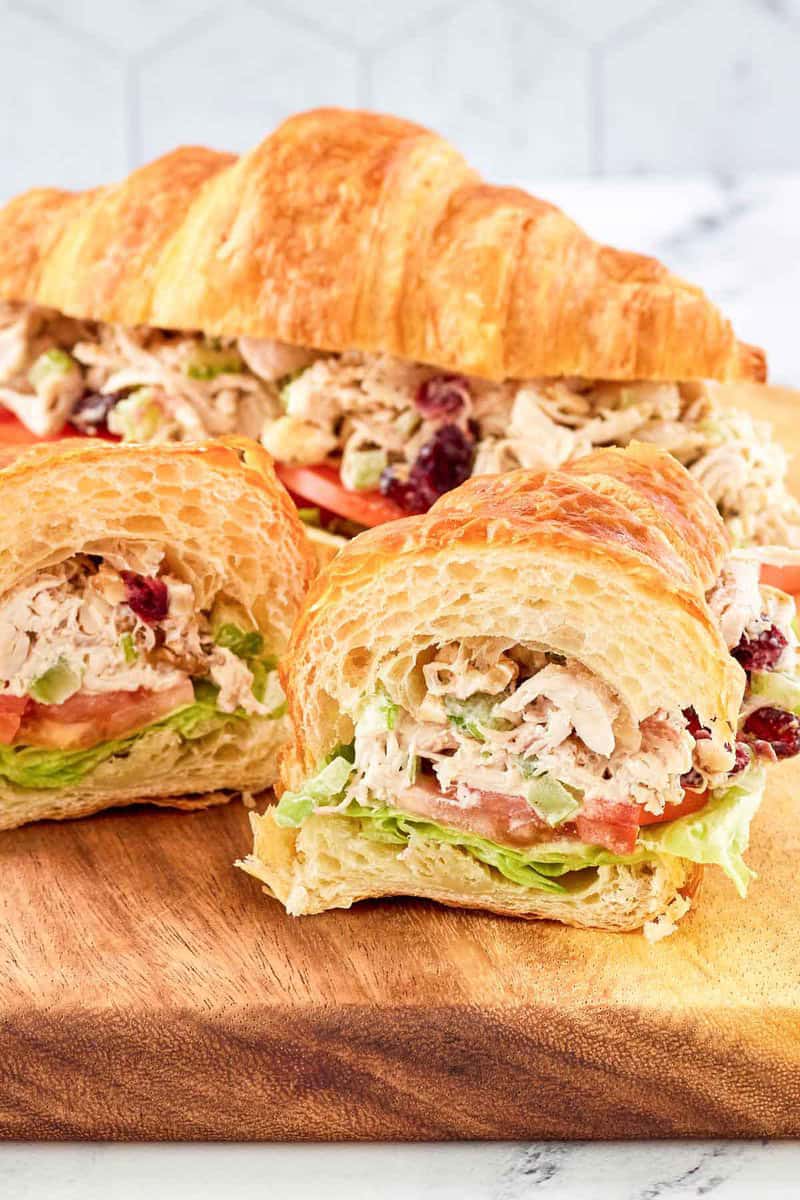 Chicken salad with cranberries and walnuts served in a croissant sandwich.